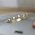 Anillo apilable dorado elegante con cinco zirconias redondas en estilo de lujo minimal - US 7 / Dorado