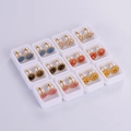 Detail view of 12 pairs of colorful sunflower smile earrings in individual white gift boxes - Smiley Sunflower Style (12 Pairs)