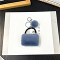 Dettaglio portachiavi a borsa in peluche blu con anello di metallo e pompon morbido - Confezione in busta singola OPP / Blu Nebbia