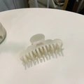 Detailopname van een golvende acetaat haarklem in crèmewit met glanzende afwerking - Ongeveer 8,5 cm / Wit (Wolk Multi-tand Klem)