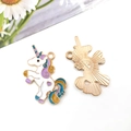 Front and back views of white enamel unicorn pendant with colorful mane and gold trim - White Enamel Unicorn 34x21