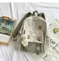 Detail view of canvas backpack with cartoon badges and plush bear charm on white cloth - Green + 5a Badge + Blush Bear