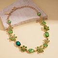 Détail de cristaux verts en forme de fleur sur un collier pendentif doré vintage - Collier-Vert