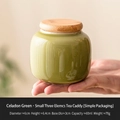 Miniature green ceramic tea tin with wooden lid and 60ml capacity in hand display - Celadon - Tea Dust Green