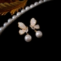 Detailed view of elegant gold butterfly earrings with pink crystal wings and white pearls - Pink Butterfly Pearl Drop (Silver Pin)