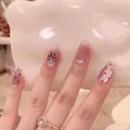 Detail of pink cat eye nails with black polka dots and hand-painted bow design - By1512 Golden Ink Dots / Glue Type