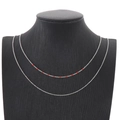 Double-layer silver stainless steel necklace with red beaded accents on a black bust - Red