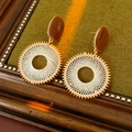 Dettaglio macro di orecchini a maglia dorata con accenti marroni su velluto verde - Stile perno in argento / Perno per orecchini in argento - Caffè