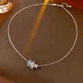 Dettaglio del ciondolo cilindrico in argento con pietre di zircone blu e bianche - Collana - Argento