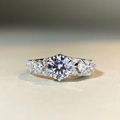 Macro shot of 1 carat round moissanite ring with side stones in silver band setting - US 5 / 6-Claw Round 1ct Pave-Silver