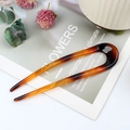U-shaped hair pin in tortoiseshell acetate finish placed on a minimalist magazine - Coffee Stripe