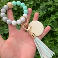Detailed view of mint green silicone bead keychain with wood charms held in hand - Mint Green Marble Pattern (Style 6)