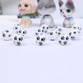 Close-up of white wooden beads with black paw prints for DIY jewelry making - White Base Black 4-Paw
