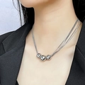 Drielaagse zilveren slangenketting met gepolijste metalen bollen gedragen door een model - Zilver Drielaagse Hanger Met Drie Ballen