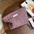 Detail of lavender tweed makeup bag featuring woven texture and simple wish label on wood - Dusty Pink