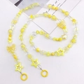 Macro detail of yellow beaded chain featuring star and flower charms with round clips - Yellow Mixed Color Beads