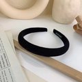 Close-up of black velvet padded headband featuring a white handmade woven label detail - Black