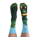 Close-up of asymmetric cotton socks featuring green camping tents and bonfire patterns - One Size / Mountain Travel