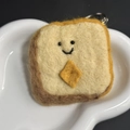 Handmade wool felt keychain featuring a cute smiling toast bread with butter detail - Toast Bread