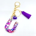 Letter U resin keychain with colorful shell flakes and a vibrant purple tassel - Letter U