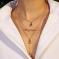 Collana dorata a tre strati con ciondoli a goccia e barra di strass su una modella - Forma a Goccia d'Acqua a Tre Livelli / Goccia d'Acqua Oro