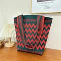 Close-up of green and red knit tote bag with chevron pattern on a wooden table - 17 Zigzag Pattern Green