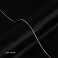 Macro shot of a 18k gold plated stainless steel box chain necklace on black silk - 1.2mm Box Chain / Gold