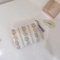 Detailed view of floral canvas storage bag with purple zipper and woven pull tab - Purple Striped Floral