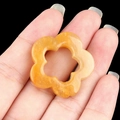 Hand holding a yellow plum blossom hollow natural crystal stone pendant charm - Topaz