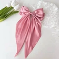 Gros plan sur un grand nœud papillon en satin rose avec texture soyeuse élégante - Rose