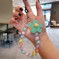 Close-up of macaron beaded phone charm with large green flower pendant and colorful beads - Green Flower Multicolor Beads