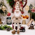 Bambola di Babbo Natale in peluche con cappello a quadri su un'auto d'epoca rossa - Stile Babbo Natale / Marrone Beige