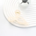 Elegant cream bow hair claw clip in a jelly-like finish with gold spring hardware - Jelly Beige