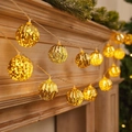 Golden faceted LED ball string lights emitting warm glow on Christmas pine needles - 1.5m 10-LED Battery Powered / Plated Yellow Ball