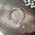 Handmade beaded bracelet with pink butterfly charm and crystals on dark wood background - S024-rhinestone Bracelet With Fuchsia Butterfly Design #sz205