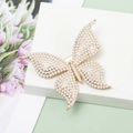 Detailed view of butterfly hair clip with sparkling pearls and elegant gold-tone base - Pearl Style / Gold