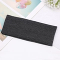 Dark grey ribbed knitted headband with cross knot design in a flat lay minimalist setup - Dark Gray