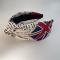 Detailansicht eines verknoteten Stirnbands aus Baumwolle mit Union Jack und Zeitungsdruck - Britische Flagge