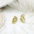 Makroaufnahme von zwei goldenen Monstera-Blattanhängern für DIY-Schmuck auf Spitze - S1 / Blatt