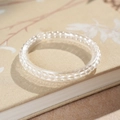 Détail macro du bracelet en perles de cristal clair sur livre fleuri, texture élégante - 4mm-Coffret Cadeau Exquis