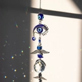 Makroaufnahme von Kristall-Sonnenfänger mit Evil Eye Anhänger und Regenbogen-Lichtreflexen - Engelsflügel Böser Blick