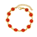 Dettaglio di bracciale dorato con dieci perle rosse lucide e chiusura a moschettone - Pietra Rossa / Rosso