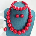 Detailed view of red oversized pearl jewelry set featuring necklace, bracelet and ring - Red