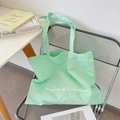 Detail view of mint green canvas tote bag with Magasin de Croissants print on a chair - Fresh Green