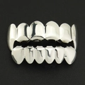Detailed macro view of silver hip hop teeth grillz set on black leather background - Fang and Flat Tooth Combo / Top Fangs Bottom Flat Silver Set