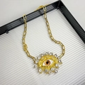 Makro-Detail der Vintage-Goldkette mit Teufelsauge-Inlay, Strass und Perlen - Rote Augen Halskette Z-2072