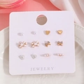 Detalle del set de 6 pares de pendientes con perlas, lazos de strass y corazones dorados - Juego de Corazón con Lazo y Perla Artificial Dorada (10226) / Dorado