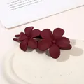 Detail of matte burgundy hair clip featuring a dual flower design on ceramic plate - Double Flower Clip - Matte Wine Red