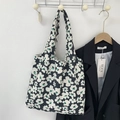 Floral print canvas tote bag hanging on a white wall next to a black blazer - Black and White Flowers