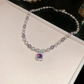 Detail van vintage parelketting met vierkante zirkoon hanger in een zacht sieradendoosje - Ketting - Zilver Roze Paars Zirconia